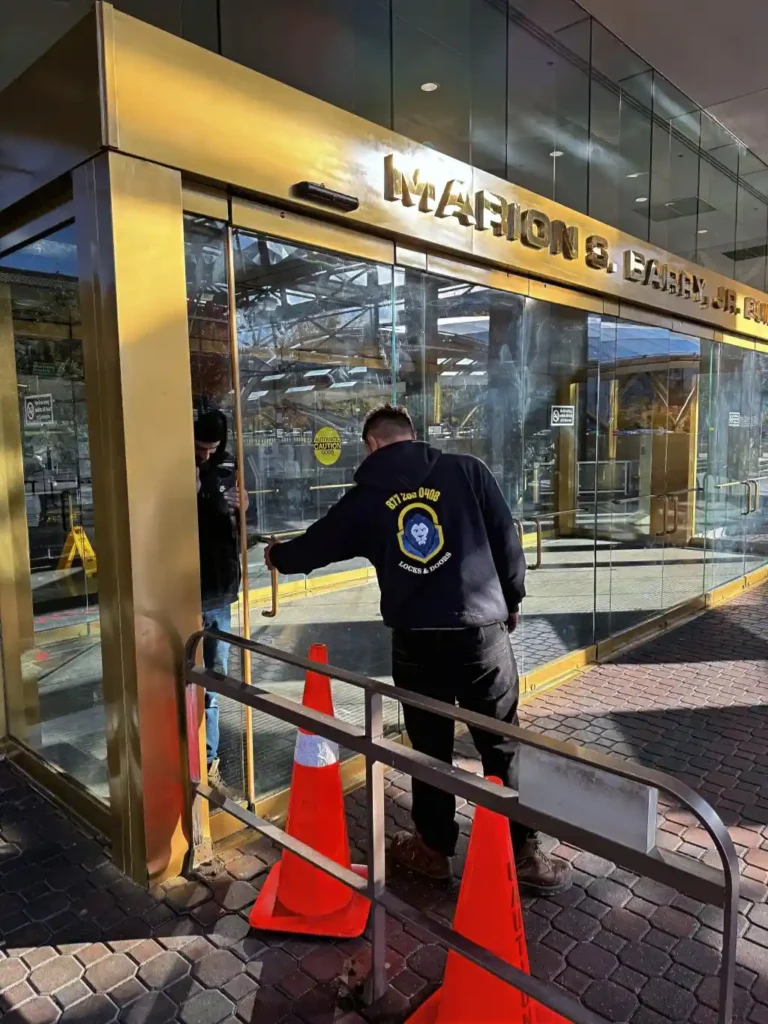 King Locksmiths technician working on a commercial glass entrance door.